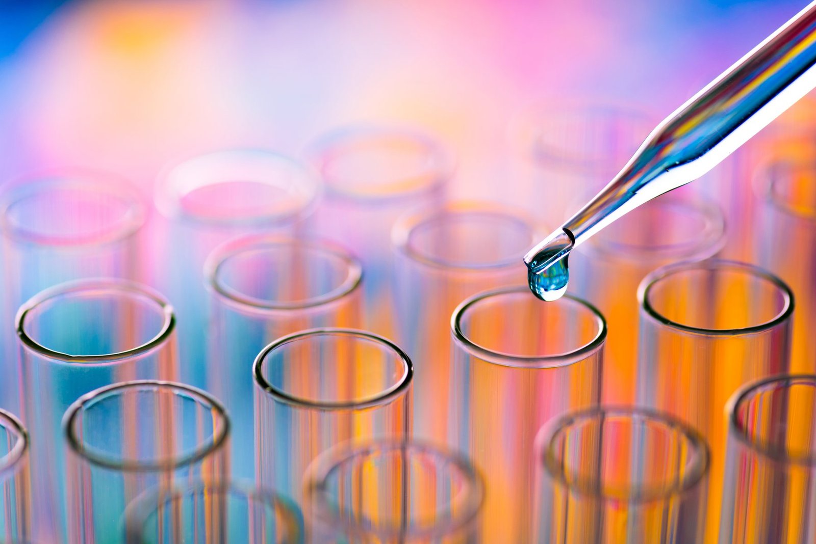 Pipette dripping chemical into a laboratory test tube