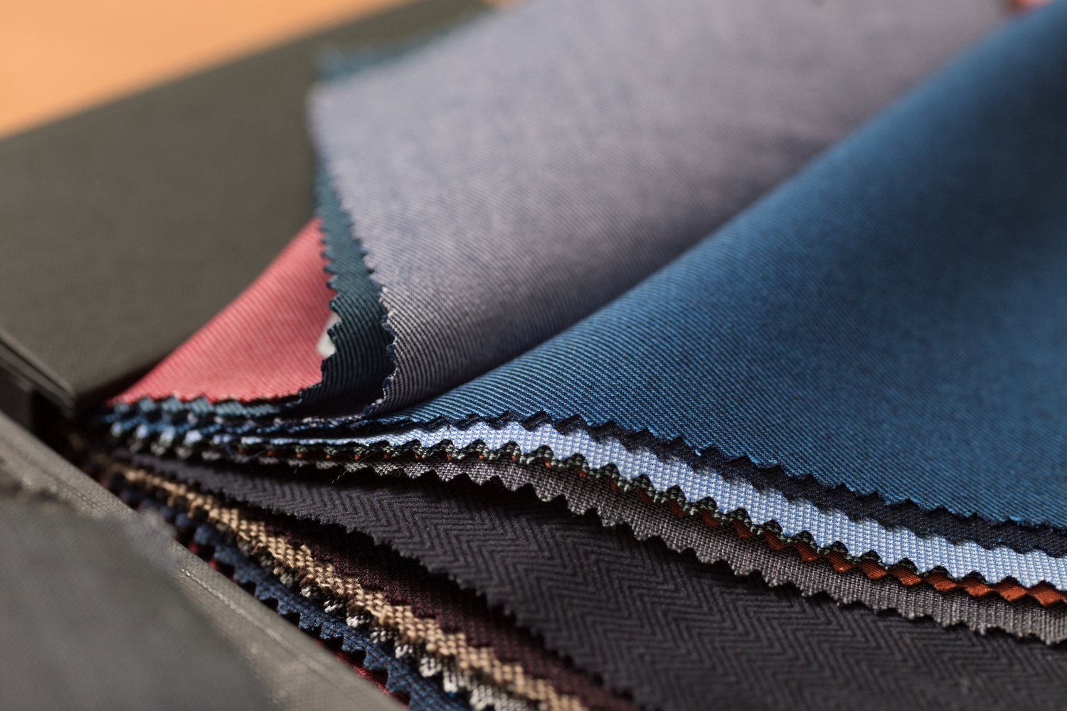 Close-up of fabric swatch book with varied wool textiles
